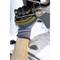 A person wearing gloves is holding a spanner and working on a vehicle component in the engine bay.