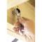A hand tightens a screw into a wooden board using a ring ratchet spanner.