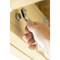 A hand is turning a bolt with a spanner in a piece of wood.