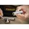 A hand is holding a metal hex key, with a spanner lying in the background. The 'STANLEY' logo is visible in the background.
