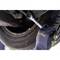A hand wearing a glove grips a spanner and tightens a screw on a car tyre.