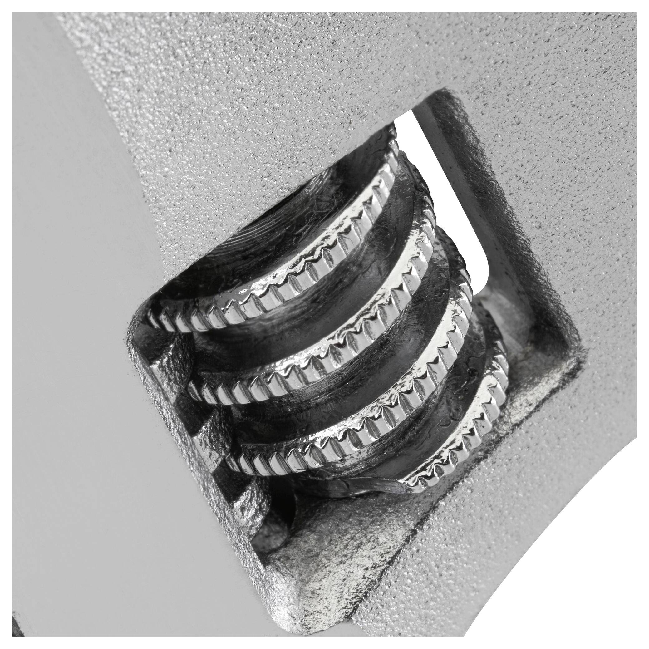 Close-up of an adjustable spanner with a finely toothed adjustment wheel for modifying the jaw width.