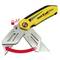 A yellow Stanley FatMax knife with an extended blade. A red arrow and a padlock symbol demonstrate the folding mechanism.