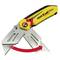 A yellow Stanley FatMax folding knife with a double blade and red arrows indicating the closing mechanism.