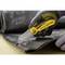 A hand wearing a black glove cuts through dark material on a table with a Stanley FatMax knife.