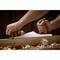 Woodwork: A person planes a wooden board with a hand plane, surrounded by wood shavings.