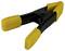 Black plastic clamp with yellow handles, brand name visible on the side. Used for securing objects.