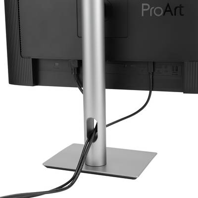 Rear view of a monitor on a desk. The screen is mounted on an adjustable height stand. Cables run along the stand.