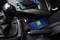 Two mobile phones charging in the car: One is resting on the centre console, the other on the passenger seat, both displaying charging indicators.