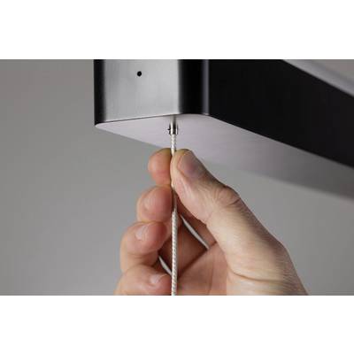 A hand pulls on a thin cable connected to the underside of a rectangular device.