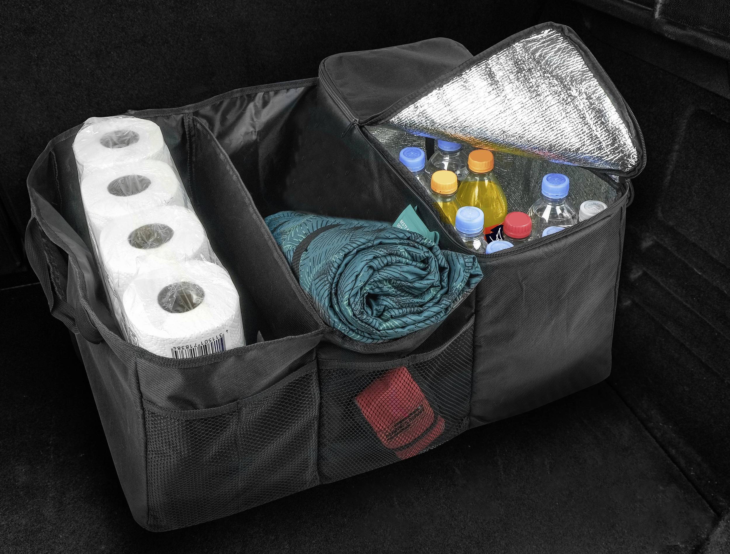 Organised boot of a car with six paper rolls, a blanket and a cool compartment for bottles and drinks. Practical for travelling.