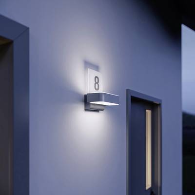 A modern exterior light illuminates the house wall. A number '8' is visible on the light fitting, which is mounted beside a door.