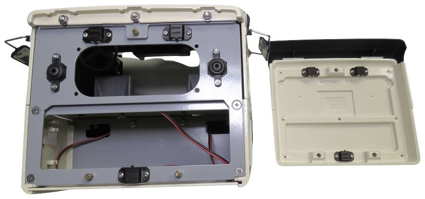 An open chassis with visible connections and cables. A separate housing component lies beside it.