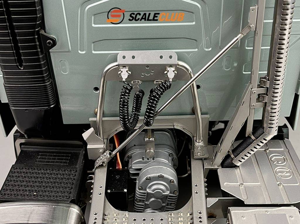 Close-up of a model lorry, showing detail of drive components and wiring. Company logo 'Scale Club' visible on the cover.