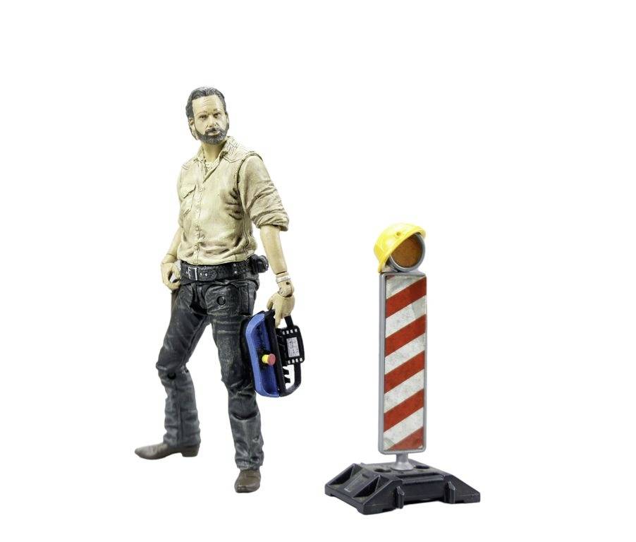 An action figure in casual clothing is holding a walkie-talkie. Next to it stands a construction marker with a yellow safety helmet.