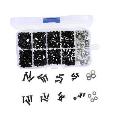 A plastic compartment box filled with black screws and nuts. Some screws and nuts are lying beside it.
