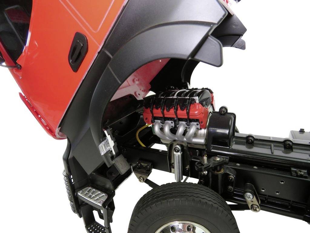 Lorry with raised bonnet reveals exposed engine block and chassis. Focus on the technical aspects for maintenance or repair.