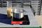 A pot is boiling on a portable gas stove outdoors. Beside it, an opened bag of dried pasta sits on the table.