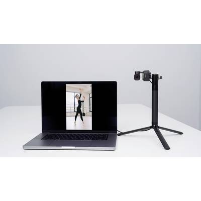 A laptop displays an image of a dancing woman. Next to it, a camera is mounted on a tripod, pointing towards the laptop.