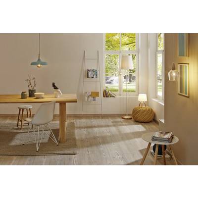 Bright living room with a wooden table, white chairs and natural light streaming through large windows. Modern lamps and decorative elements accentuate the design.