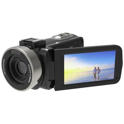 A video camera with its display folded out shows an image of two people on the beach at sunset.