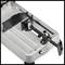 Metal vice with clamping mechanism on a grey platform, used for securing workpieces during machining.