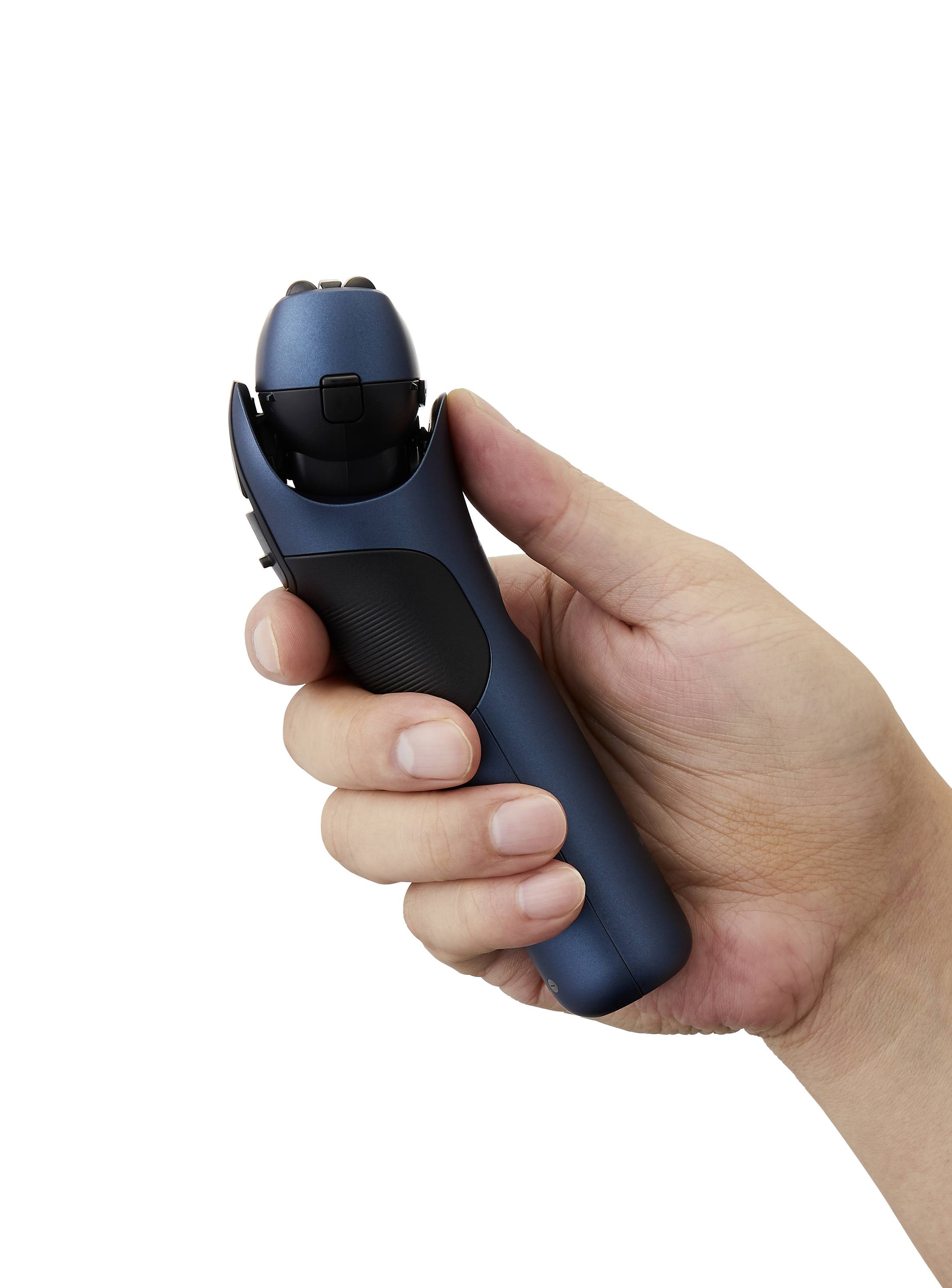 A hand is holding a blue, cordless electric razor with an ergonomic design.