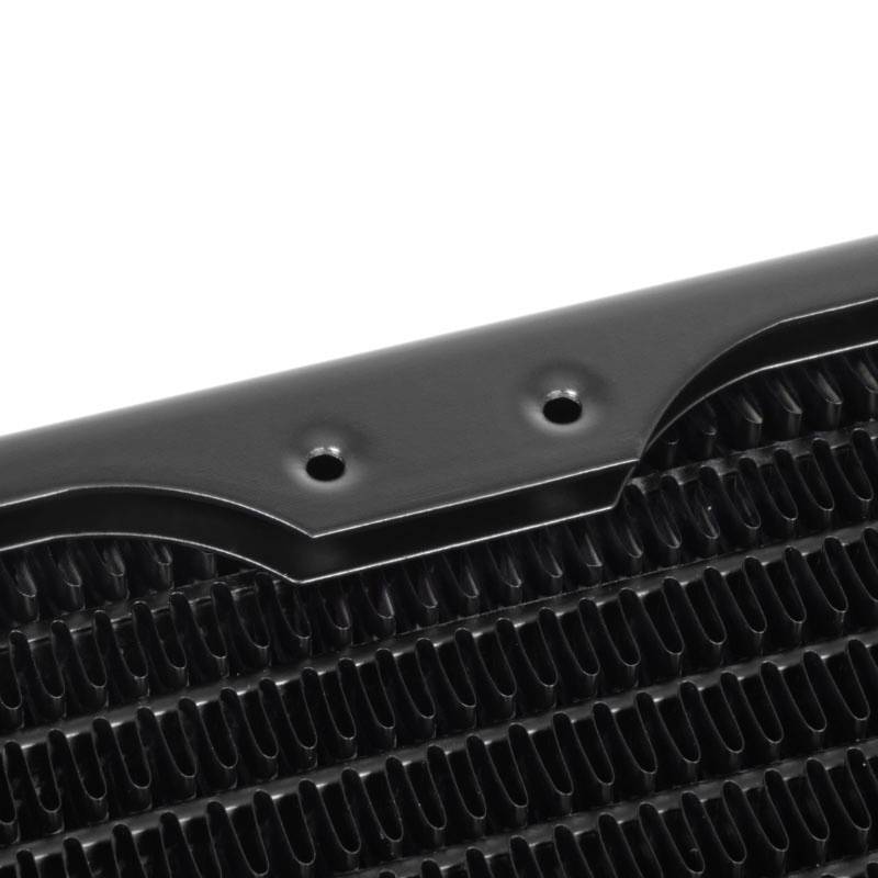 Close-up of a radiator section with black fins and drilled holes along the edges to aid cooling.