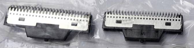 Two black and silver razor heads in a plastic bag.