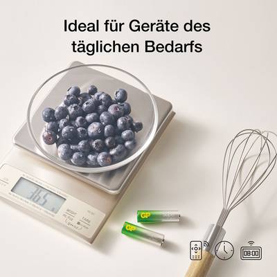 On a digital kitchen scale, there is a bowl of blueberries. In the foreground, two batteries and a whisk are visible. Text: 'Ideal for everyday devices'.