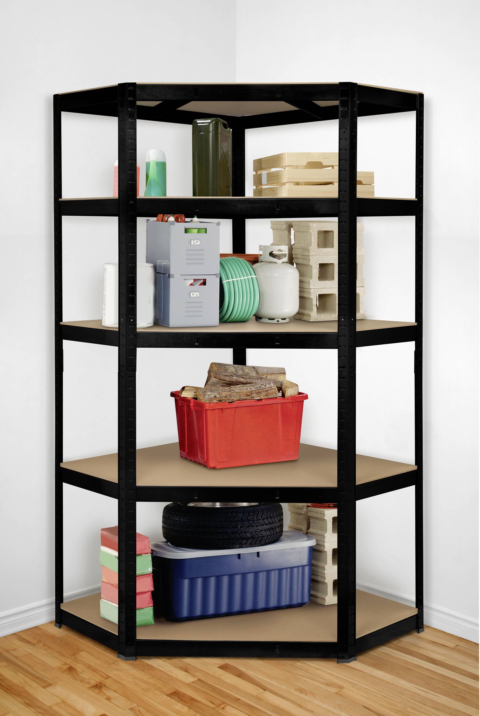 A black metal corner shelving unit stands in a corner. It contains various objects such as tools, tyres, cardboard boxes and a red crate.