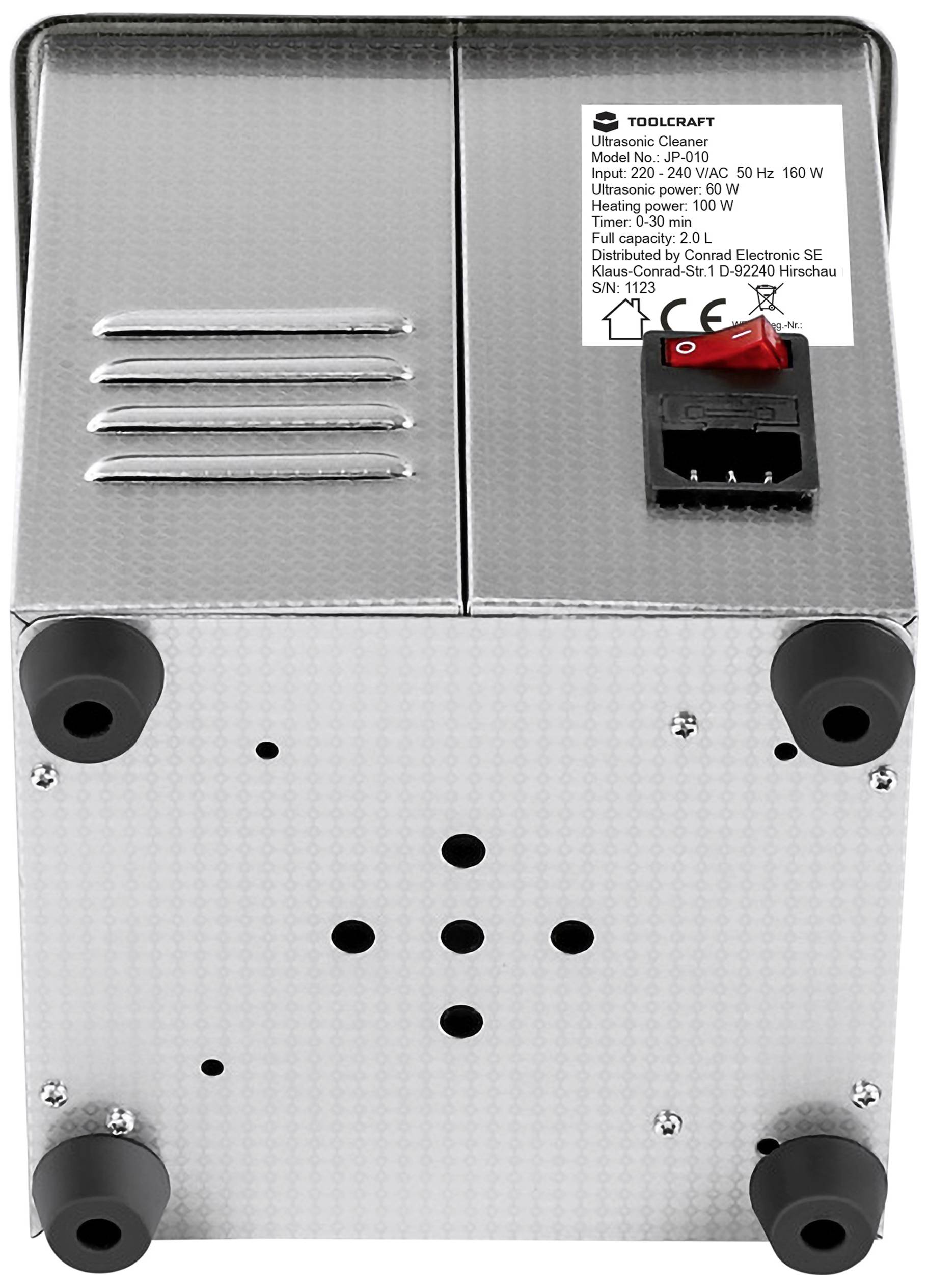 A metallic device with a black switch and power connection at the top, four round feet at the bottom. A label displays the model and technical details.