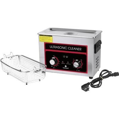 An ultrasonic cleaner with a metal basket beside it and a power cable, the device has rotary knobs for timer and heating control.