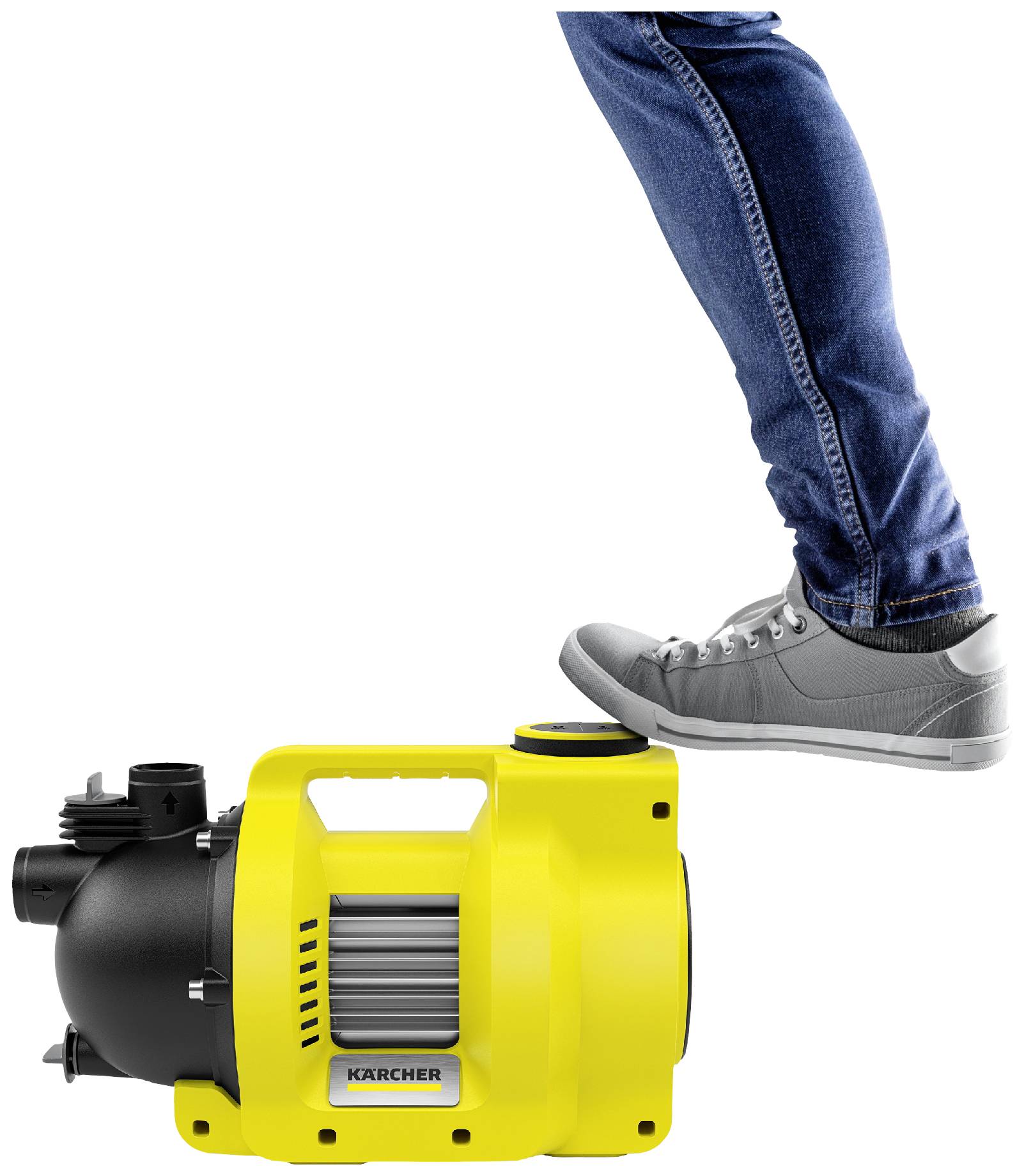 A person is standing with one foot on a yellow water pump.