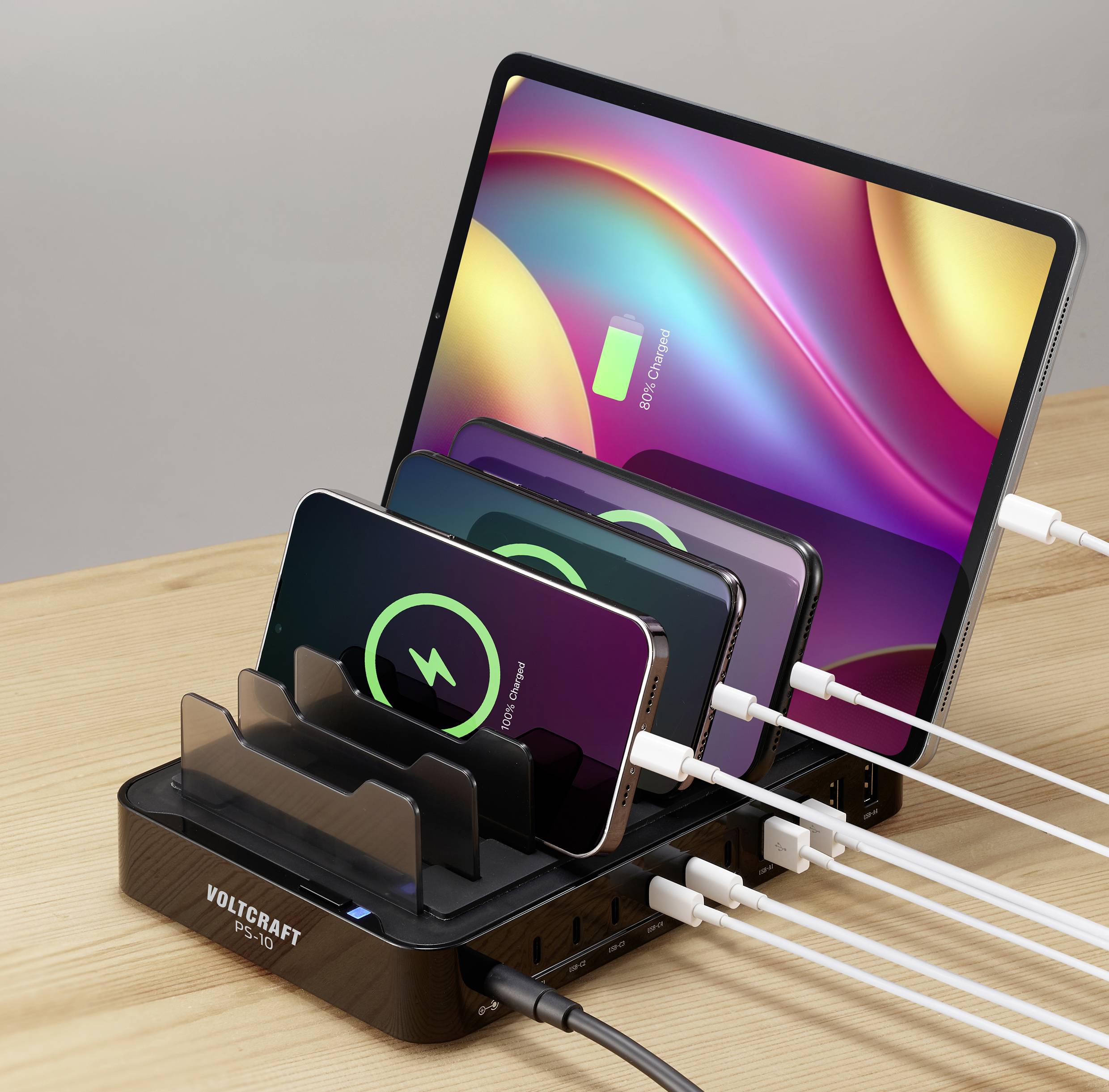 Tablets and smartphones are being charged on a charger. A charging symbol is displayed on the screens.