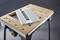 'A woodworking table with a removable metal part and four screws in the top right corner.'