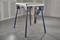 A mobile workshop table with folding legs, suitable for various craftwork in a workshop environment.