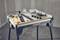 'Workbench with various tools and accessories, including screwdrivers, clamps and a tape measure, arranged on a tabletop.'