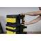 A person stacking a yellow and black toolbox and latching the handle of another box into place.