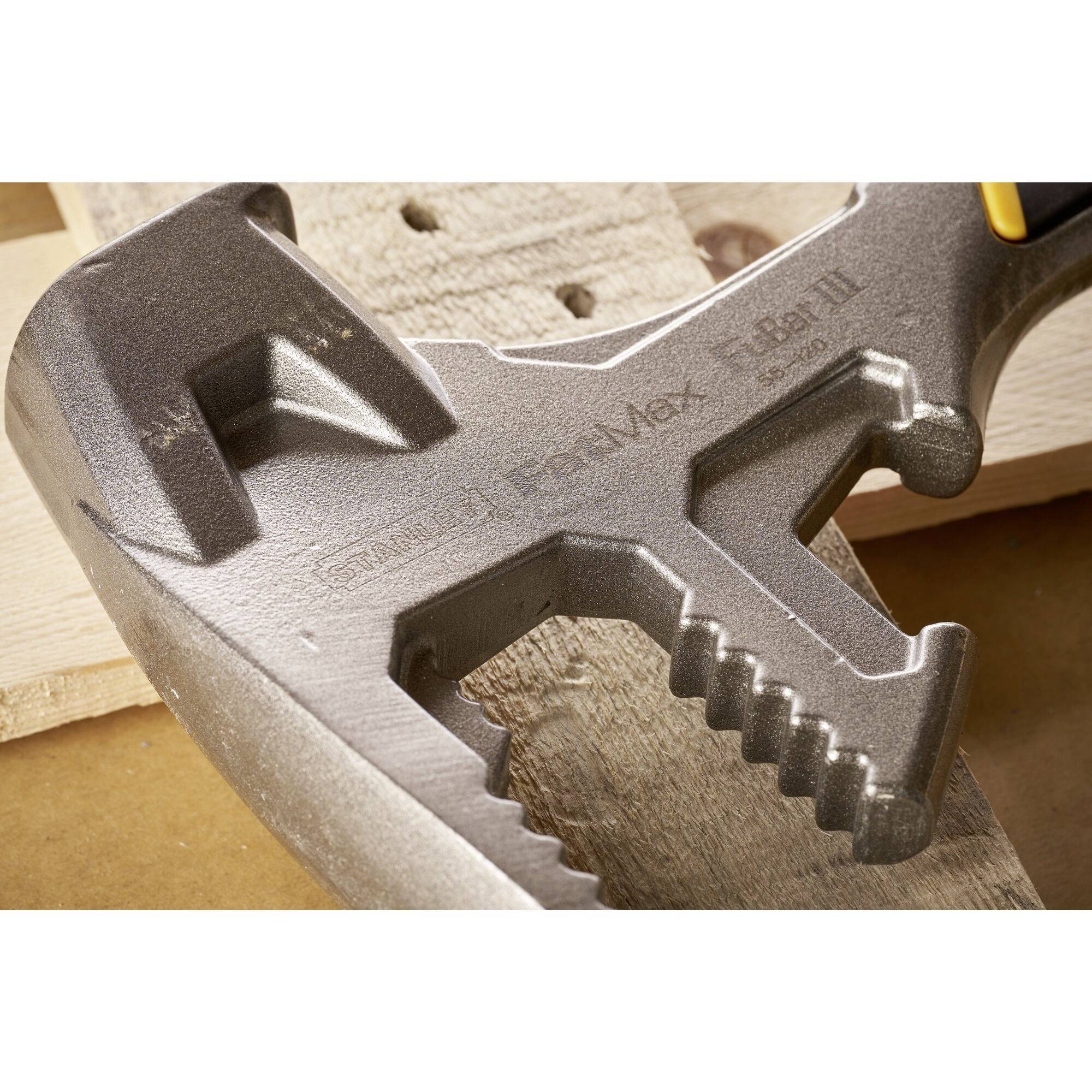 An adjustable spanner lies on wood, with some teeth and grooves visible, demonstrating precision and versatility.