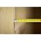 A yellow tape measure is measuring the width of a wooden board. The marking is at approximately 4.5 cm.