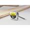 A Stanley 'PowerLock 8m' tape measure is lying on a table next to a wooden beam and a pen.