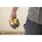 A hand is holding a yellow laser measuring device. The image focuses on the measuring tool in a craftsman's context.