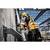Construction worker wearing protective clothing and a hard hat, working with a drill on a steel structure at a building site.