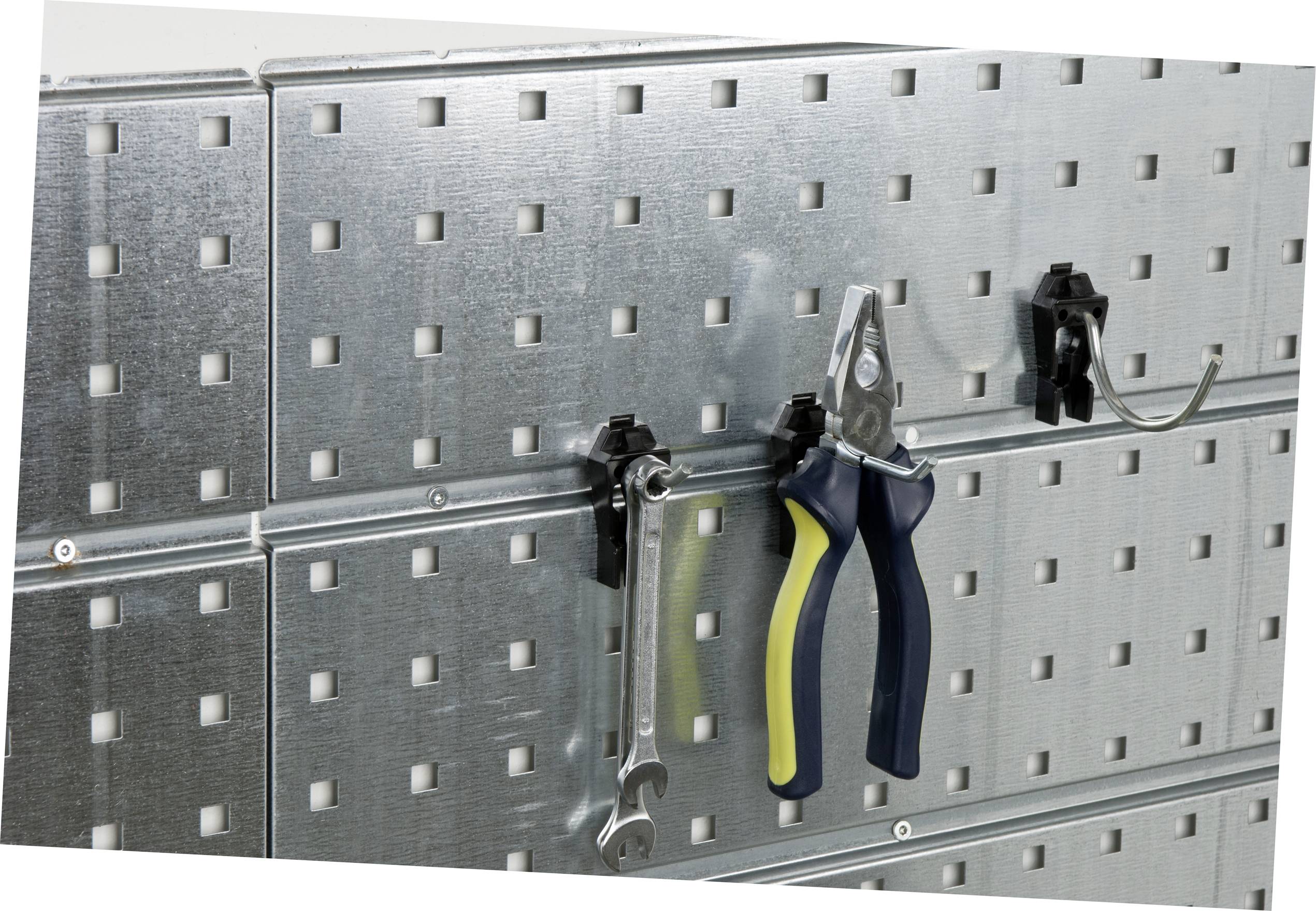 Metal perforated wall panel with hooks, on which a pair of pliers and a spanner are hanging. For organising tools in a workshop.
