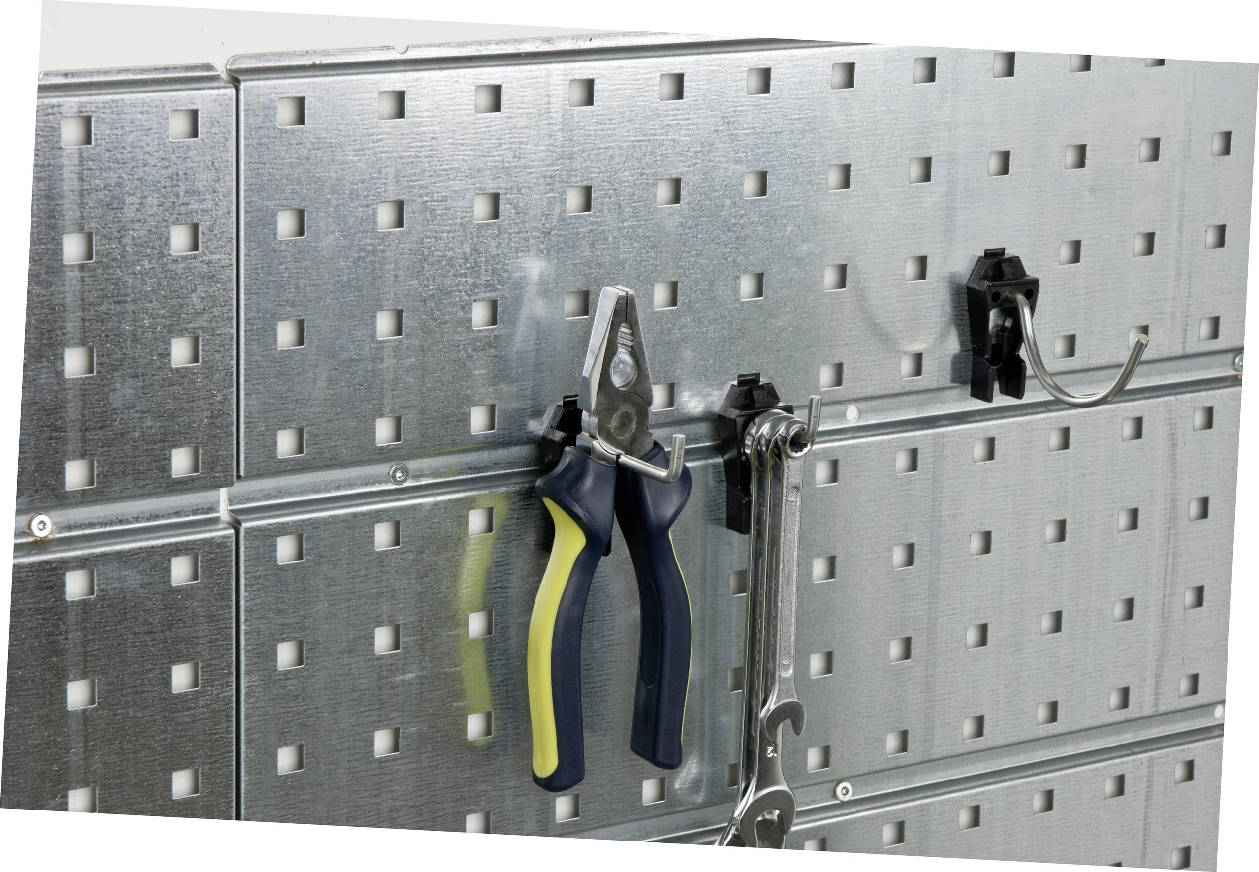 Metal tool wall with square holes. A pair of pliers and a spanner are hanging on hooks.
