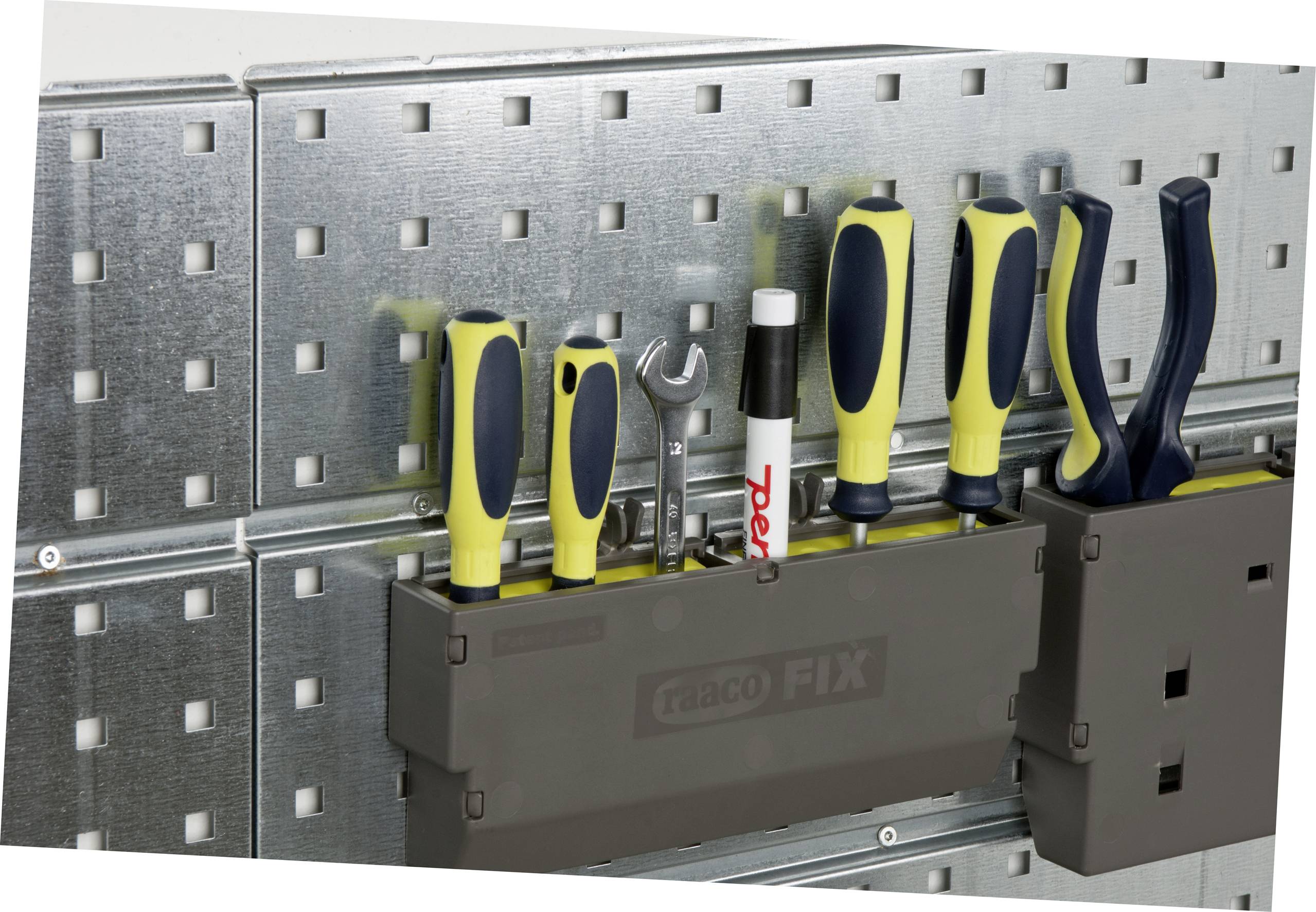 Tool wall with various hand tools, including screwdrivers, spanners, and pliers, neatly arranged in holders.