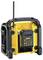 Portable yellow and black construction site radio with a long antenna and robust casing. Battery visibly mounted on the back.