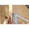 A person tightens a screw with a spanner, securing a metal plate to a wooden post.