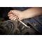 A hand is holding a spanner and tightening a screw on a vehicle engine.